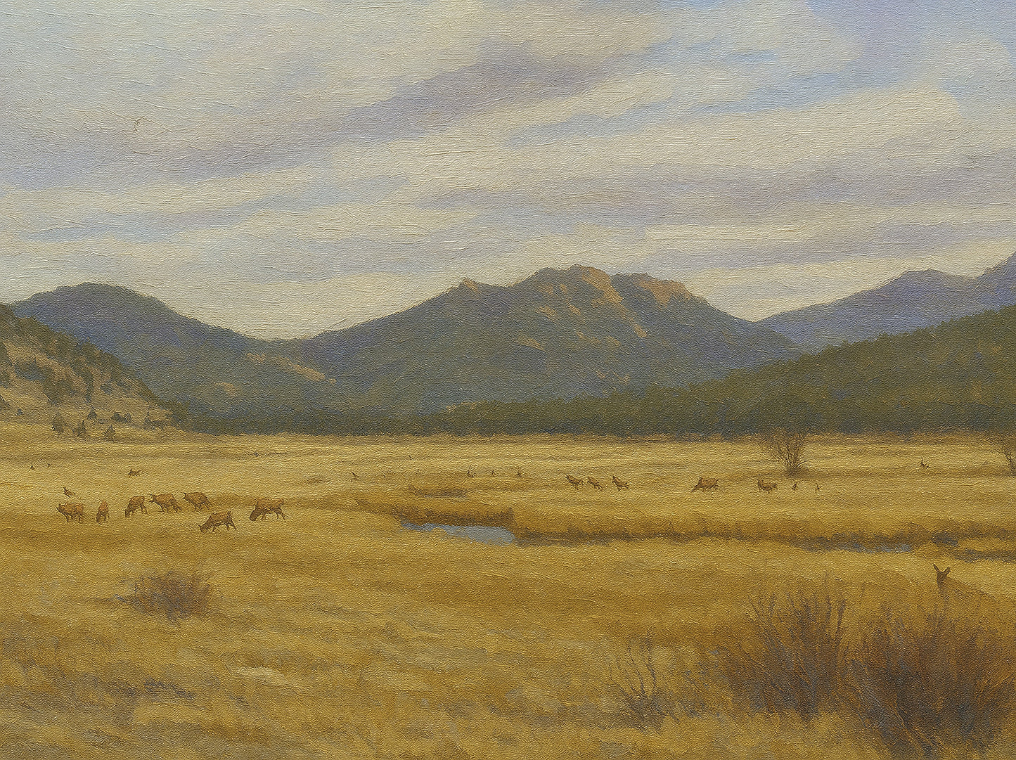 Herd of elk grazing across a golden meadow with blue-grey forested mountains beyond.